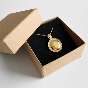 Minimalistische gouden ronde hanger ketting in een bruine kraft papieren geschenkdoos