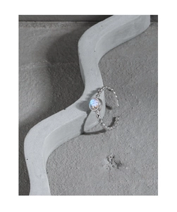 Detail von S925 Silber Mondstein Ring mit gedrehtem Band auf minimalistischem Display