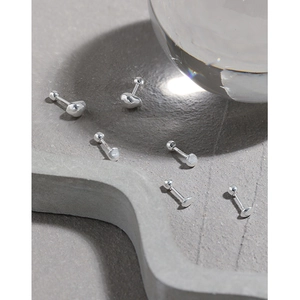 Boucles d'oreilles boules S925 en argent sterling sur un plateau en pierre grise