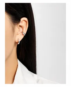 Detalle de pendientes de aro de plata S925 y earcuff geométrico puesto en modelo