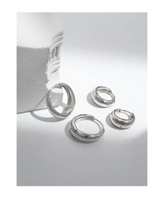 Detalle macro de cuatro pendientes de aro en plata S925 pulida de varios tamaños