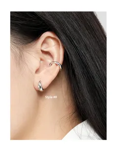 Detalle del set de ear cuff y pendientes de aro Estilo 8 en plata pulida minimalista