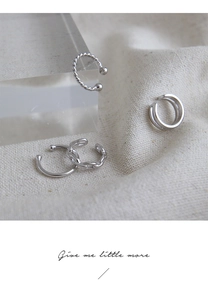 Dettaglio di quattro ear cuff in argento S925 con texture intrecciate e superfici lisce