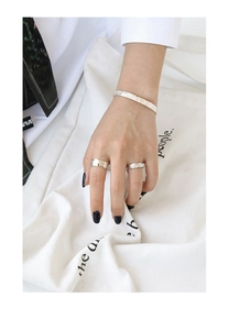 Detailaufnahme von silbernen S925-Armbändern und Ringen mit gehämmerter Texturoberfläche