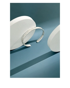 Detail eines S925 Sterling Silber Armreifs mit unregelmäßiger Hammerschlag-Textur in Silberglanz