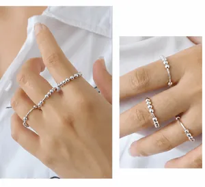 Dettaglio di anelli sovrapposti in argento sterling con design a sfere geometriche