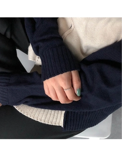 Dettaglio anello sottile in oro con cinque piccole perle indossato sul dito