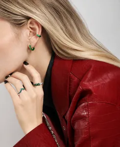 Detailed view of twisted S925 silver ring and ear clips with green enamel on a model