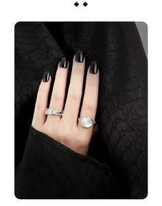 Close-up of S925 silver rings with rock texture and opal inlay on a black background