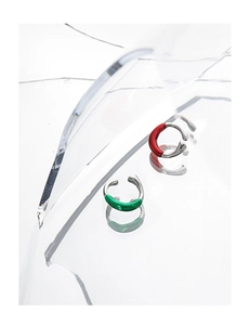 Macro detail of silver twisted ear clips with vibrant red and green enamel coating