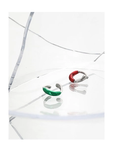 Detail of minimalist silver ear cuffs with green and red enamel twist texture