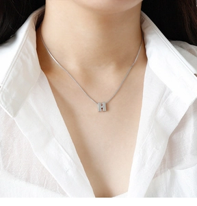 Gros plan d'un pendentif lettre H en argent 925 sur une chaîne à mailles fines pour femme