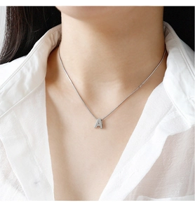 Gros plan d'un collier avec pendentif lettre A en argent sterling S925 sur un mannequin