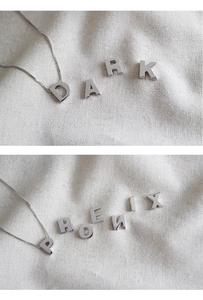 Détail macro des pendentifs alphabets D P en argent massif S925 avec chaîne box