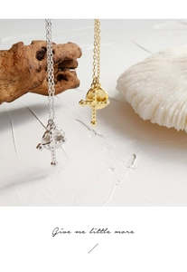 Detailed shot of cross pendant necklace in gold and silver finish with textured surface