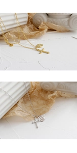 Detail of S925 sterling silver cross and textured round pendant necklace in gold and silver