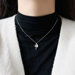 S925 sterling silver cross and round disc pendant necklace worn on a black sweater