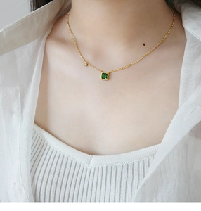 Detail van de S925 zilveren ketting met groene vierkante zirkoon om de hals van model