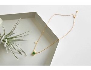 Detail van de vierkante smaragd zirkoon ketting met gouden ketting en ster-hanger