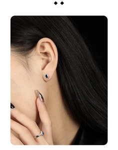 Detail of silver twisted border earrings and ring with marquise-cut blue zircon stones