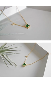 Macro-detail van gouden ketting met vierkante smaragd-zirkonia en klein diamantaccent