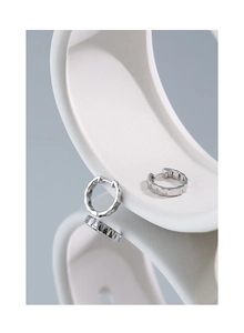 Macro detail of minimalist S925 sterling silver hoop earrings with irregular geometric texture