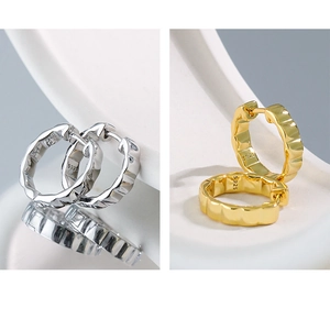 Detail view of gold and silver S925 sterling silver hoop earrings with wavy texture