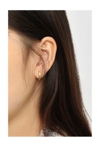 Close-up of minimalist gold plated S925 sterling silver huggie earrings with textured grid