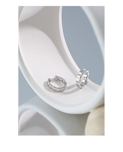 Macro shot of silver S925 sterling silver hoop earrings with geometric faceted texture