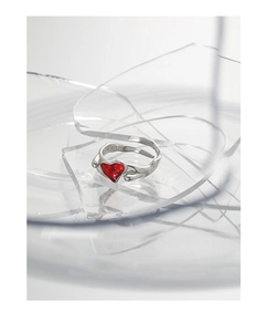Detalle macro de anillo de plata S925 con corazón rojo y banda irregular