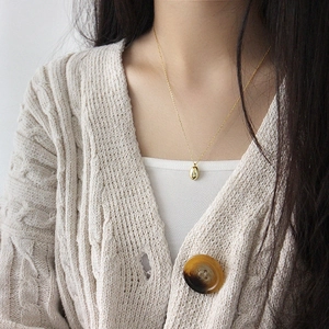 Collier élégant en argent S925 doré avec pendentif goutte d'eau sur un gilet en maille