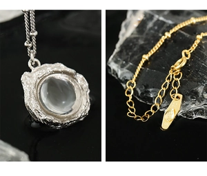 Détail macro d'un pendentif argenté texture lave avec pierre de lune et poinçon argent 925
