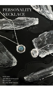 Détail de pendentifs en argent texture lave avec labradorite et pierres de cristal blanc