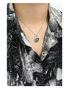 Gros plan du pendentif en labradorite avec texture de lave sur une chaîne en argent fin