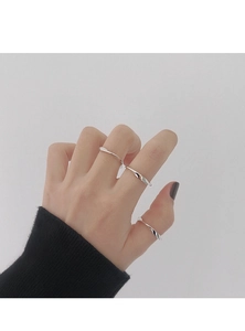 Set de tres anillos de plata pulida con diseño minimalista de torsión en la mano