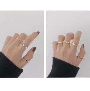 Primer plano de anillos minimalistas dorados y plateados con diseño de giro Mobius