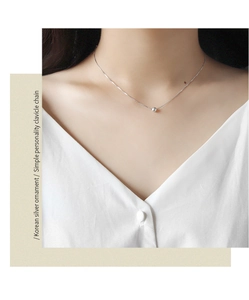 Close-up of minimalist S925 sterling silver clavicle chain with a single round bead pendant