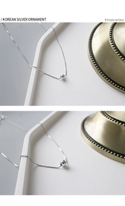 Detailed view of polished sterling silver bead pendant on a delicate box chain