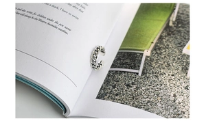 Detail of vintage S925 sterling silver chain ring placed on book pages by a pool
