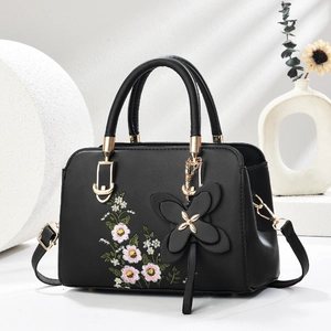 Elegant black handbag with floral embroidery and gold hardware for a classic look