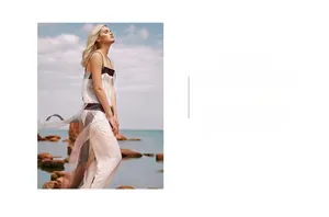 Detail of color-block slip dress showing lightweight fabric against seaside background