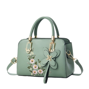 Elegant light green handbag with floral embroidery and golden hardware accents