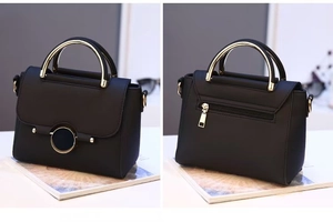 Detail view showing textured black leather exterior with gold metal handle and rear zipper pocket