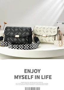 Detail of printed shoulder bags with patterned straps and gold hardware closures