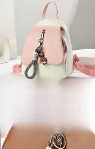 Détail du sac à dos en cuir rose et beige avec un joli pendentif de lapin marron