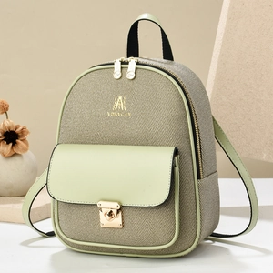 Detail of light green leather and beige canvas texture on mini backpack with gold lock