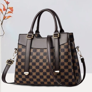 Classic checkered tote bag with clover print and gold hardware from a 45-degree angle