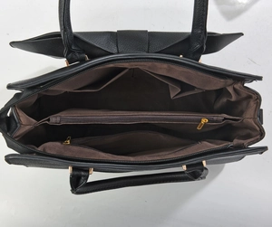 Innenansicht der schwarzen Schleifen-Handtasche mit mehreren Fächern und Goldbeschlägen