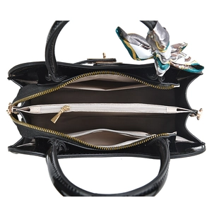 Detail view of the multi-compartment interior and silk scarf on the black handbag