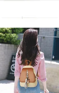 Détail d'un sac à dos bicolore avec pendentif lapin mignon sur des escaliers